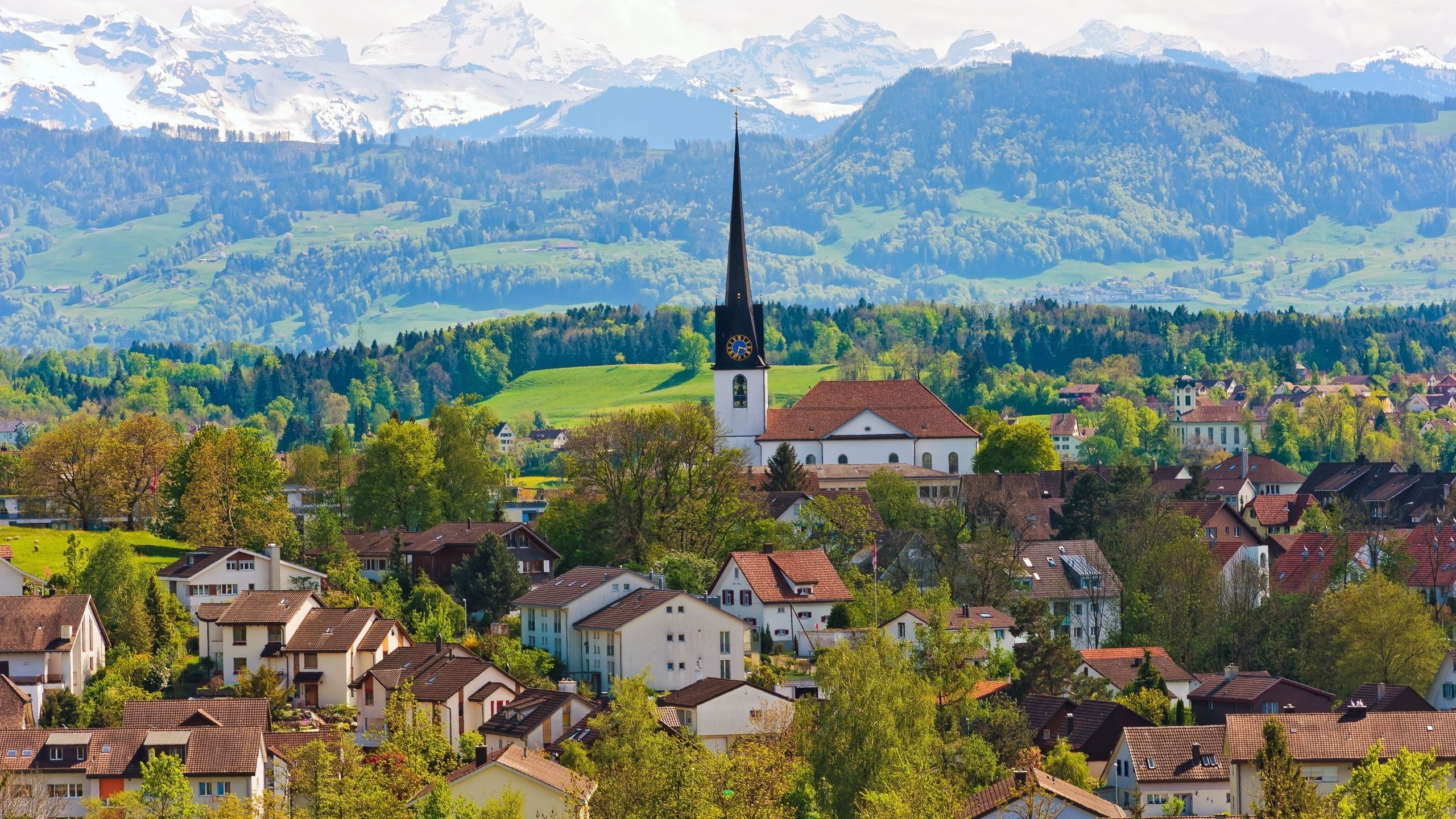 Weißes Und Braunes Betonhaus in Der Nähe Von Grünen Bäumen Und Bergen Tagsüber. Wallpaper in 2560x1440 Resolution