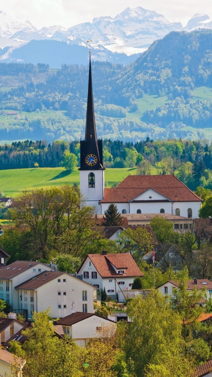 Weißes Und Braunes Betonhaus in Der Nähe Von Grünen Bäumen Und Bergen Tagsüber. Wallpaper in 720x1280 Resolution