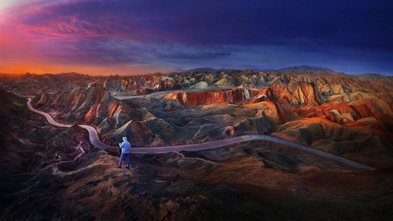 Woman in White Shirt and Blue Denim Jeans Standing on Brown Rock Formation During Daytime. Wallpaper in 1280x720 Resolution