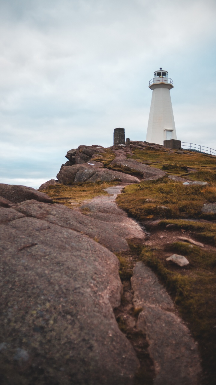 White and Black Lighthouse on Brown Rocky Hill Under White Cloudy Sky During Daytime. Wallpaper in 720x1280 Resolution