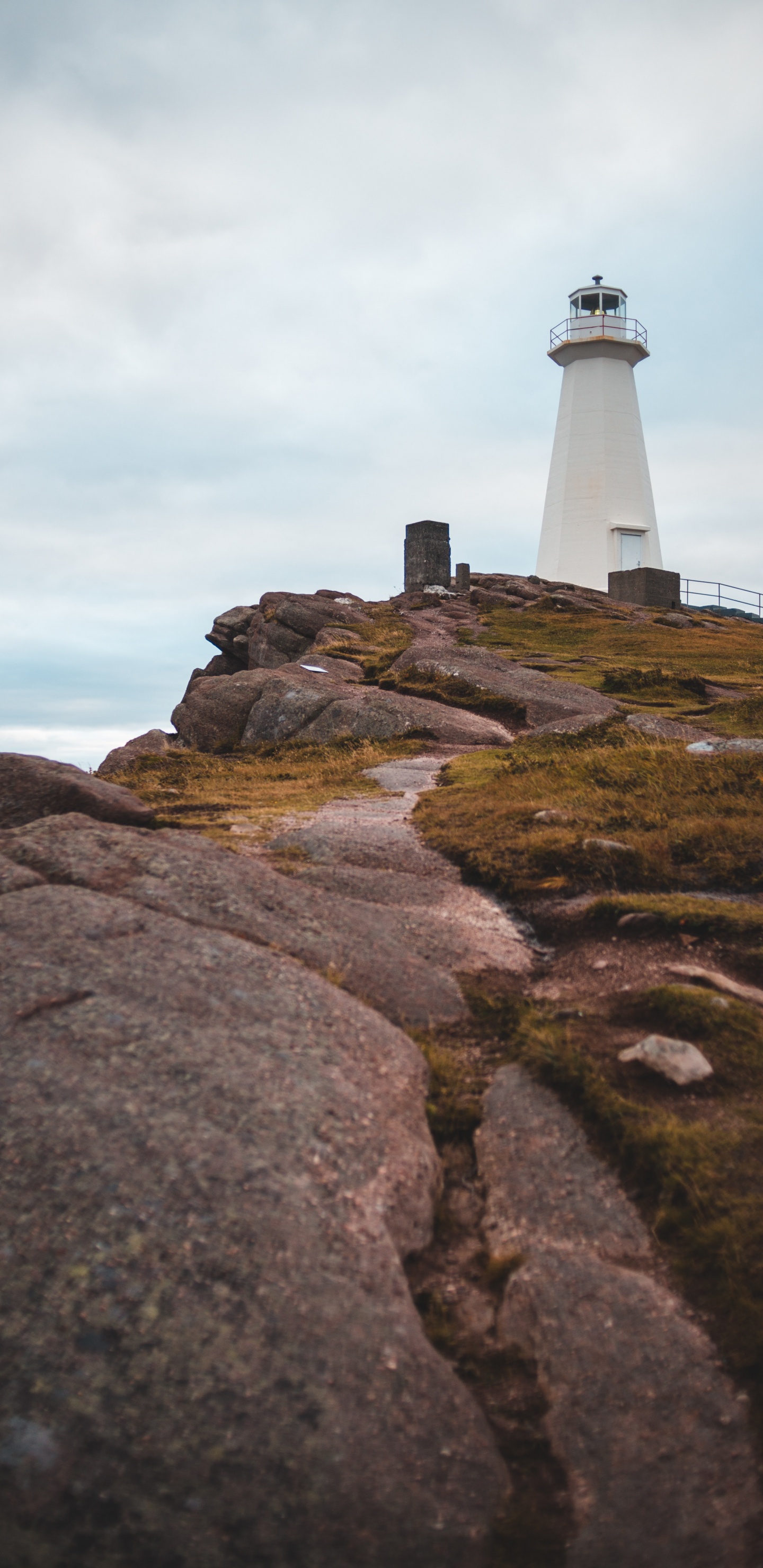 Weißer Und Schwarzer Leuchtturm Auf Braunem Felsigem Hügel Unter Weißem Bewölktem Himmel Tagsüber. Wallpaper in 1440x2960 Resolution