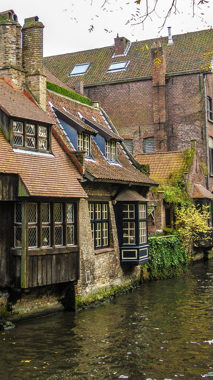 Brown Brick Building Beside River During Daytime. Wallpaper in 750x1334 Resolution