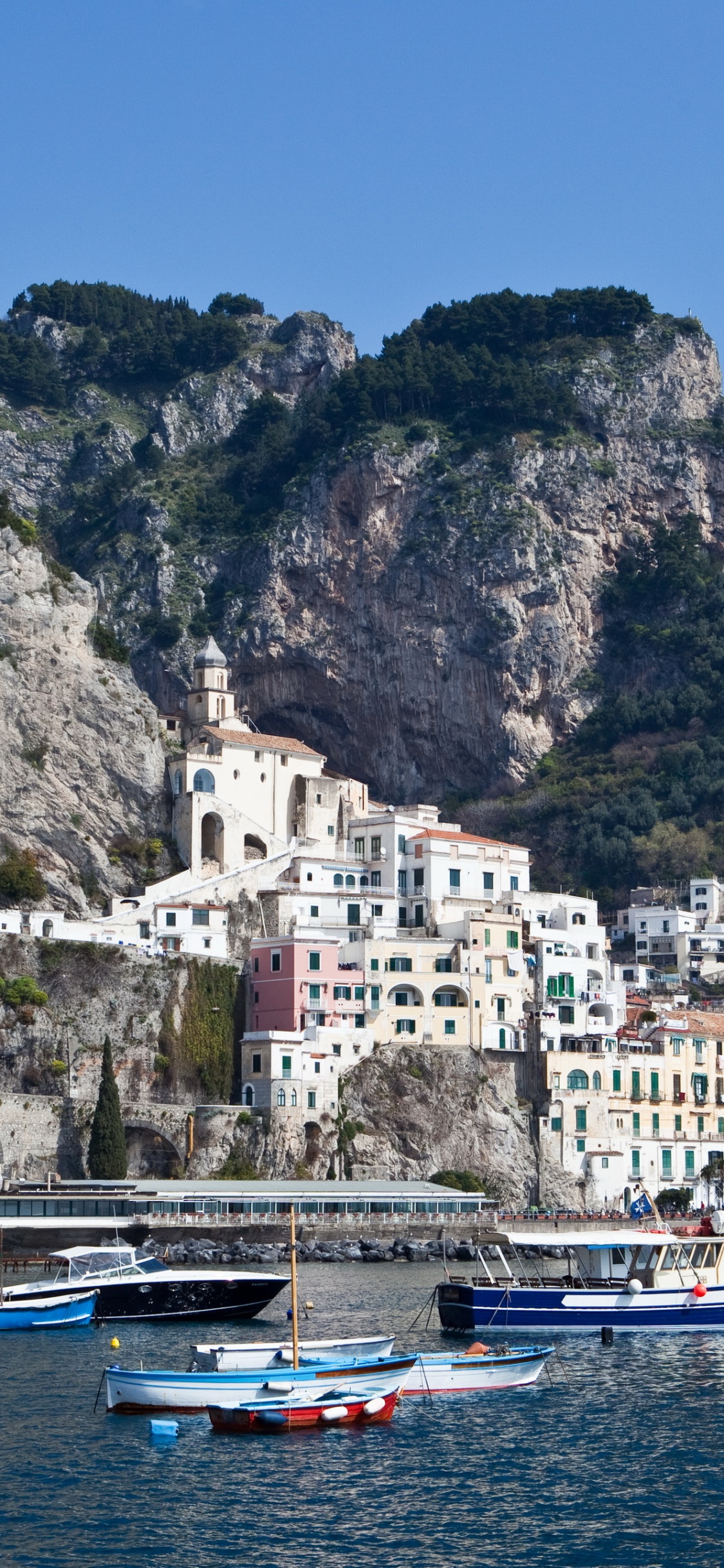 Bateau Blanc et Bleu Sur un Plan D'eau Près D'un Bâtiment en Béton Blanc Pendant la Journée. Wallpaper in 1125x2436 Resolution