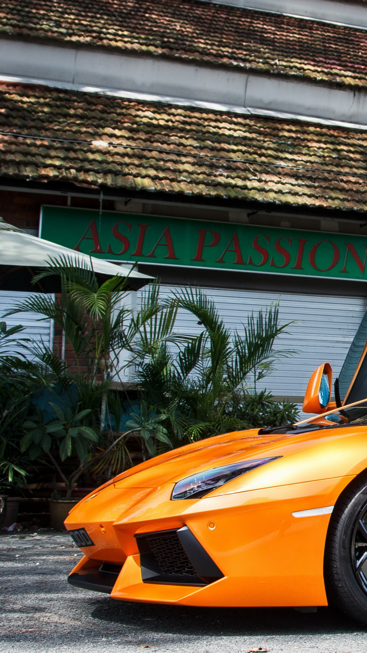 Orange Ferrari 458 Italia Parked Near Building. Wallpaper in 750x1334 Resolution