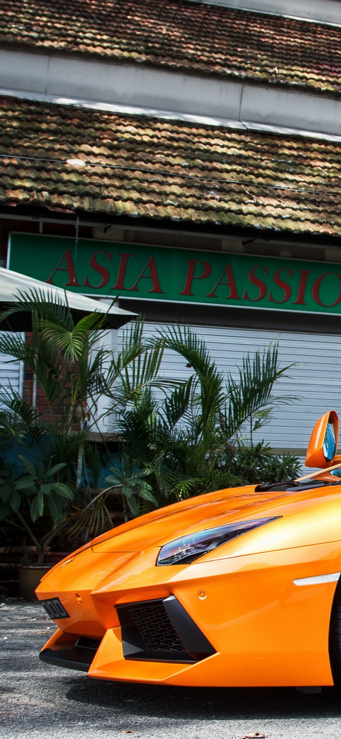 Oranger Ferrari 458 Italia in Der Nähe Des Gebäudes Geparkt. Wallpaper in 1125x2436 Resolution