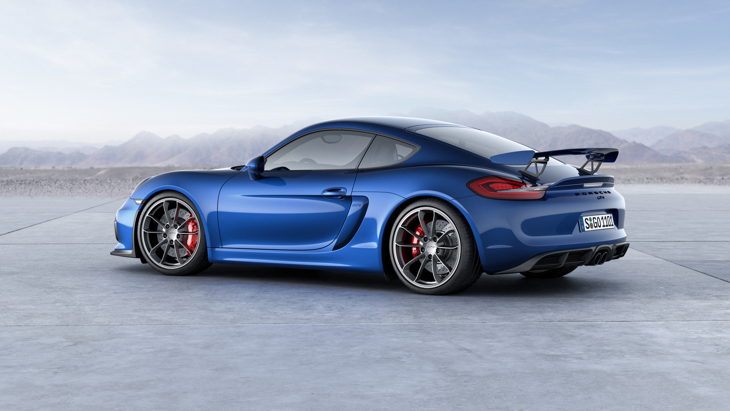 Blauer Porsche 911 Auf Grauem Betonpflaster. Wallpaper in 2560x1440 Resolution