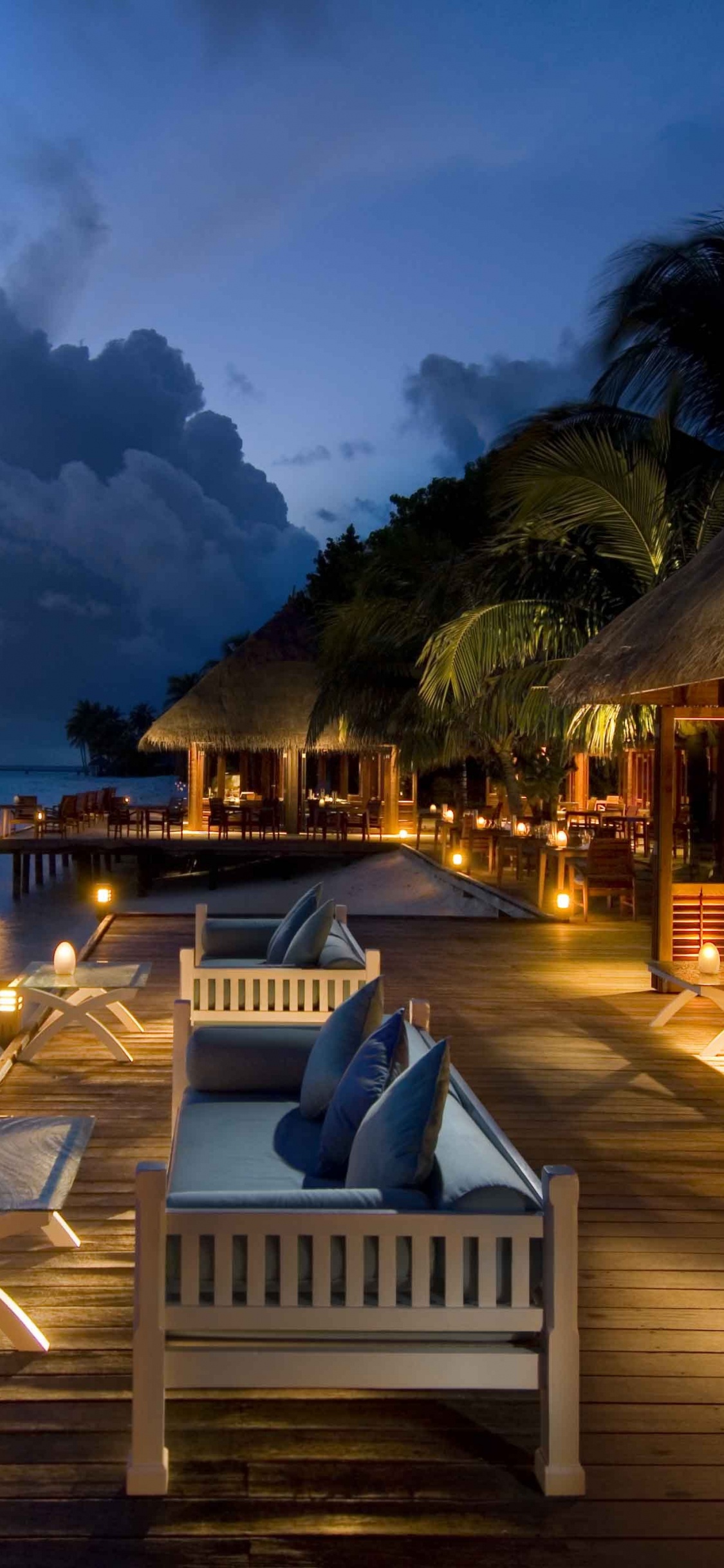 White and Brown Wooden House Near Body of Water During Daytime. Wallpaper in 1125x2436 Resolution