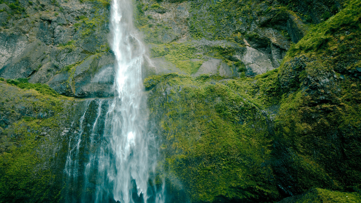 Wasser Fällt Auf Grünen Moosbedeckten Felsen. Wallpaper in 1366x768 Resolution