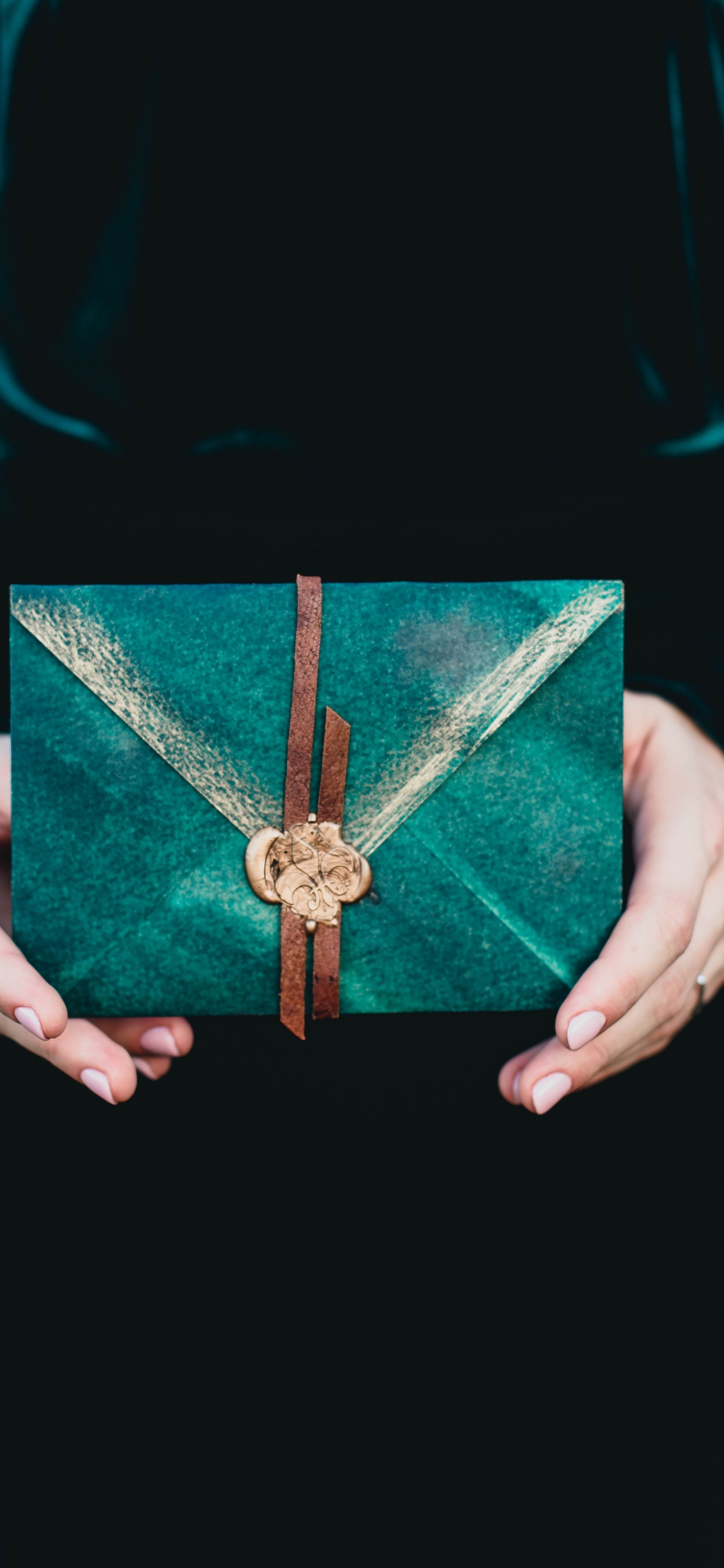 Persona Sosteniendo Una Cruz Roja y Dorada. Wallpaper in 1242x2688 Resolution