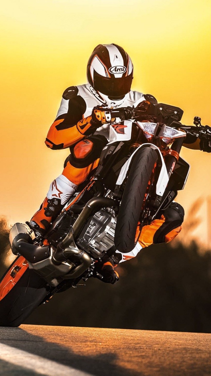 Mann im Orangen Und Schwarzen Motorradanzug, Der Auf Dem Motorrad Fährt. Wallpaper in 720x1280 Resolution