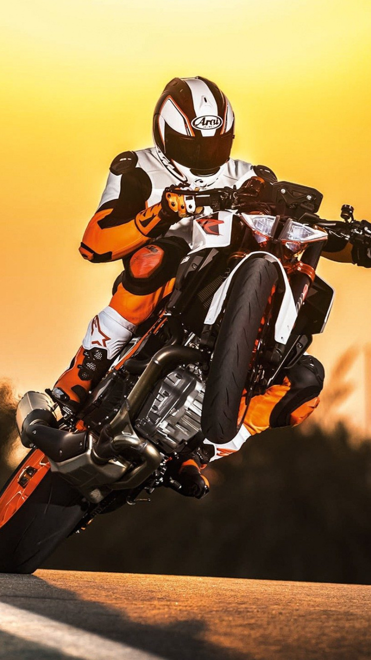 Mann im Orangen Und Schwarzen Motorradanzug, Der Auf Dem Motorrad Fährt. Wallpaper in 750x1334 Resolution