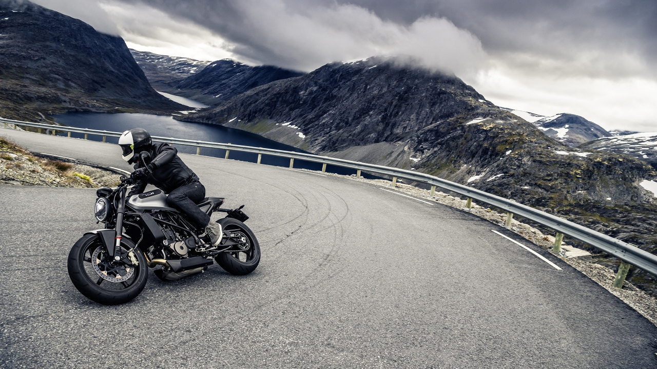 Schwarzes Motorrad Unterwegs in Der Nähe Des Berges Tagsüber During. Wallpaper in 1280x720 Resolution