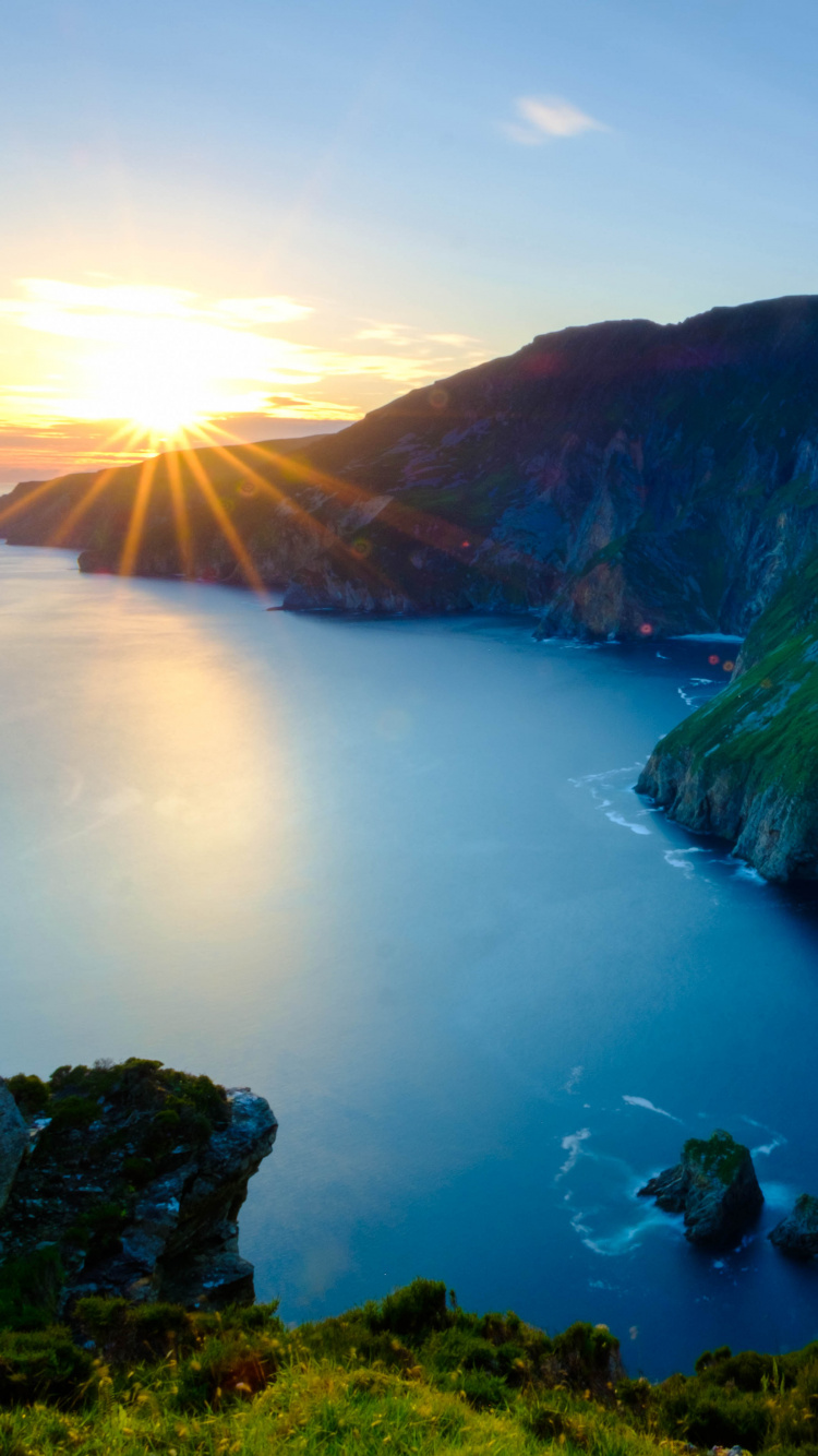 Green and Brown Mountain Beside Body of Water During Daytime. Wallpaper in 750x1334 Resolution