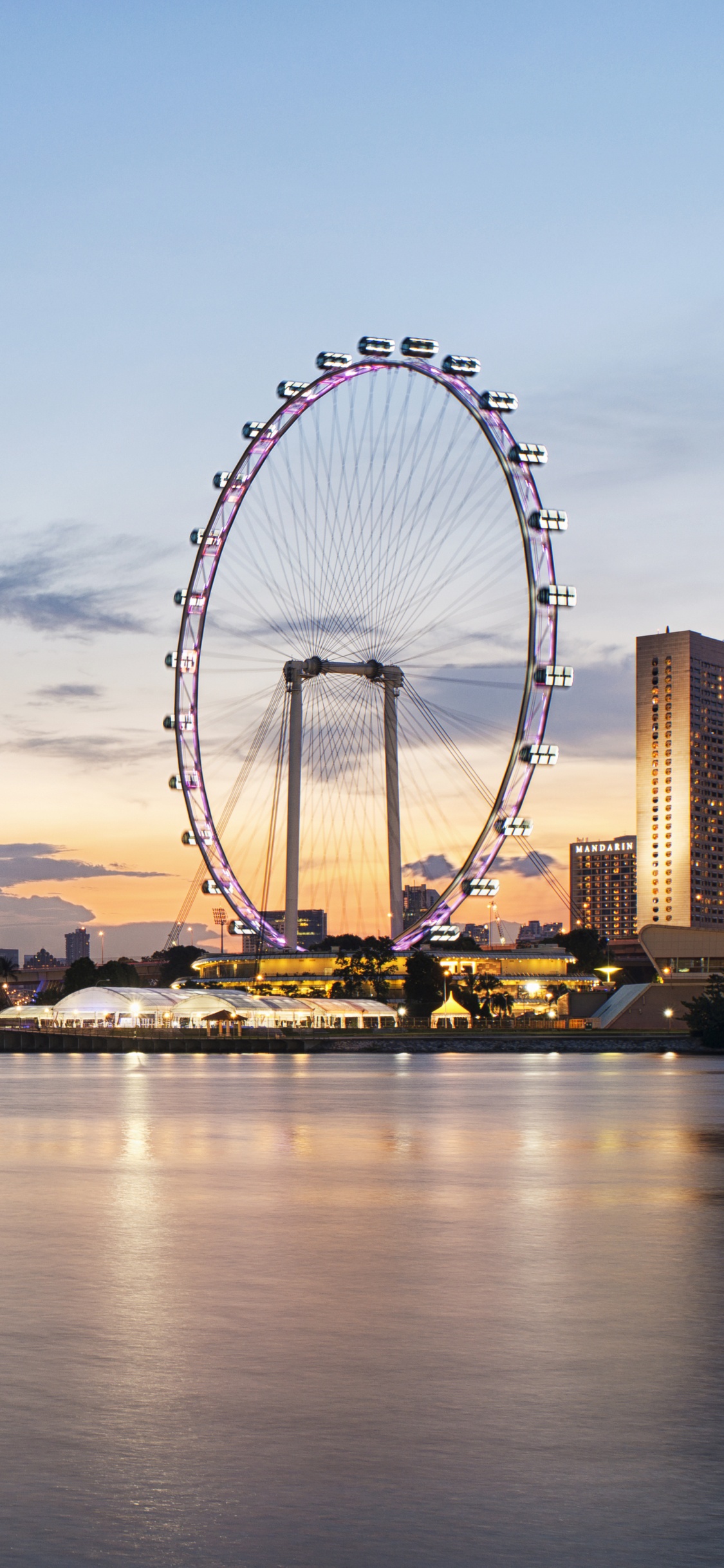 Ferris Wheel Near City Buildings During Night Time. Wallpaper in 1125x2436 Resolution