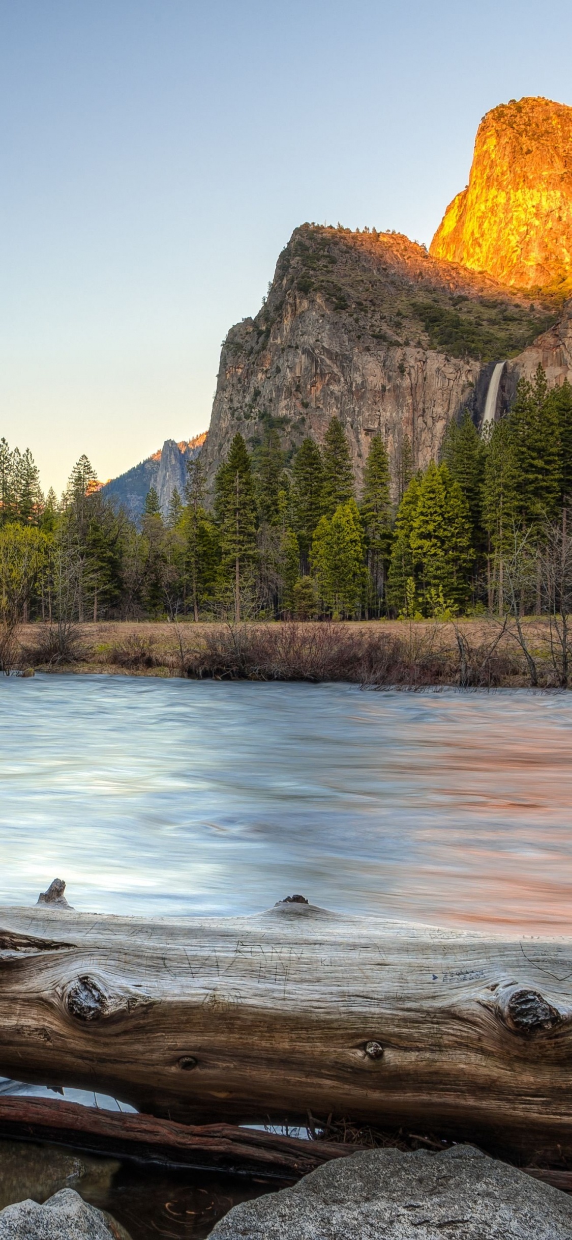 Brown Rocky Mountain Beside River During Daytime. Wallpaper in 1125x2436 Resolution