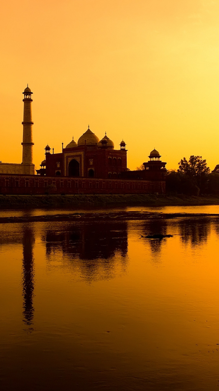Bâtiment en Béton Marron et Blanc Près D'un Plan D'eau Pendant le Coucher du Soleil. Wallpaper in 750x1334 Resolution