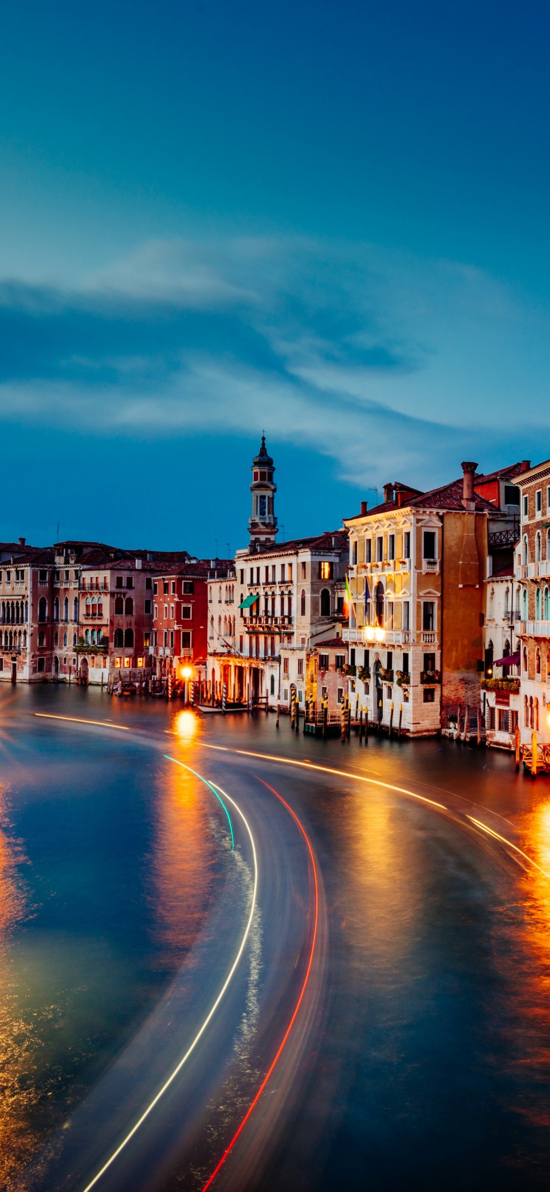 Zeitraffer-Fotografie Von Autos Auf Der Straße Zwischen Gebäuden Während Der Nachtzeit. Wallpaper in 1125x2436 Resolution