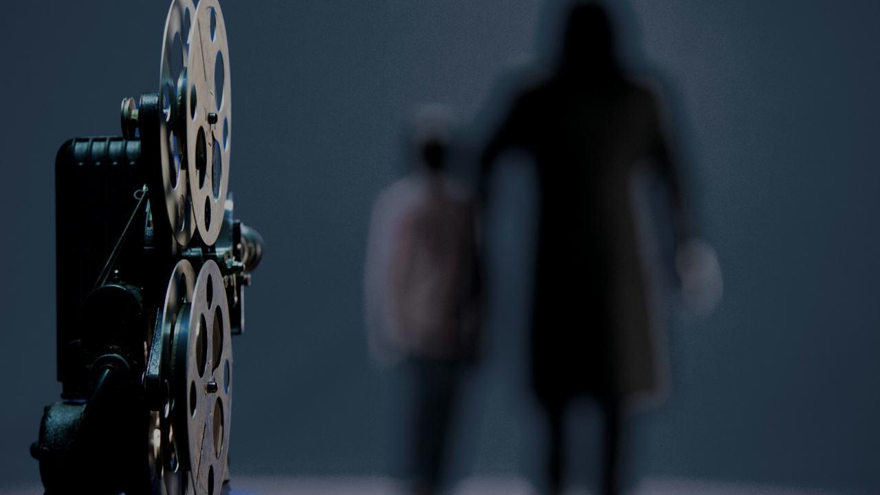 Hombre Con Chaqueta Negra de Pie Junto a Una Decoración de Pared Redonda Azul y Amarilla. Wallpaper in 1280x720 Resolution