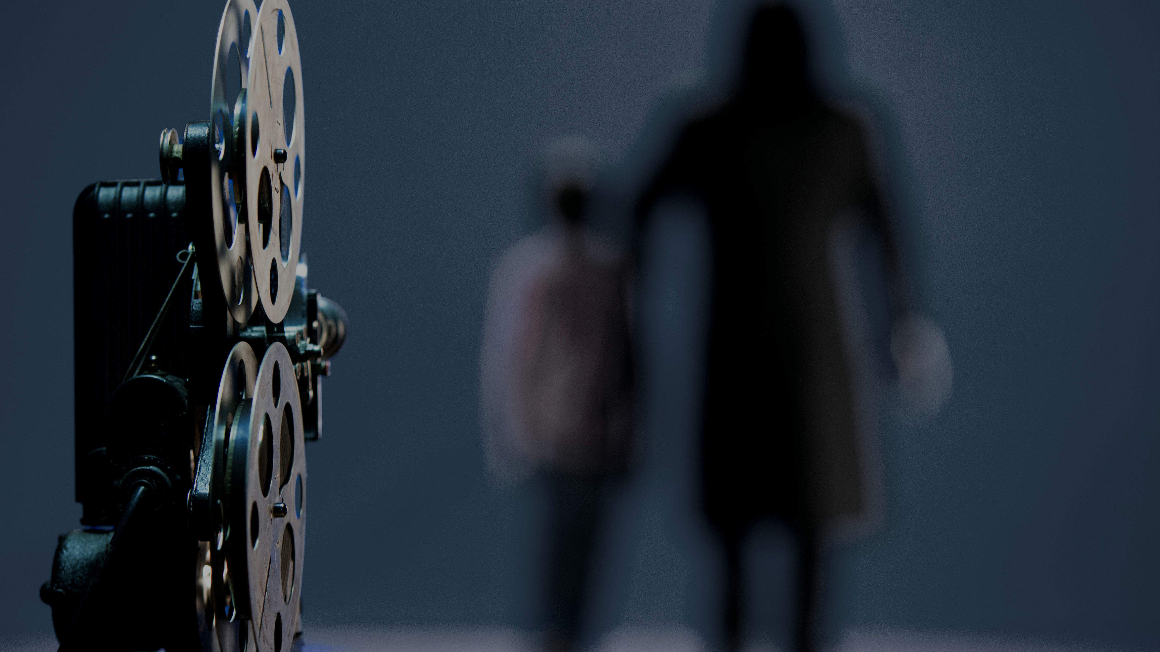 Hombre Con Chaqueta Negra de Pie Junto a Una Decoración de Pared Redonda Azul y Amarilla. Wallpaper in 3840x2160 Resolution