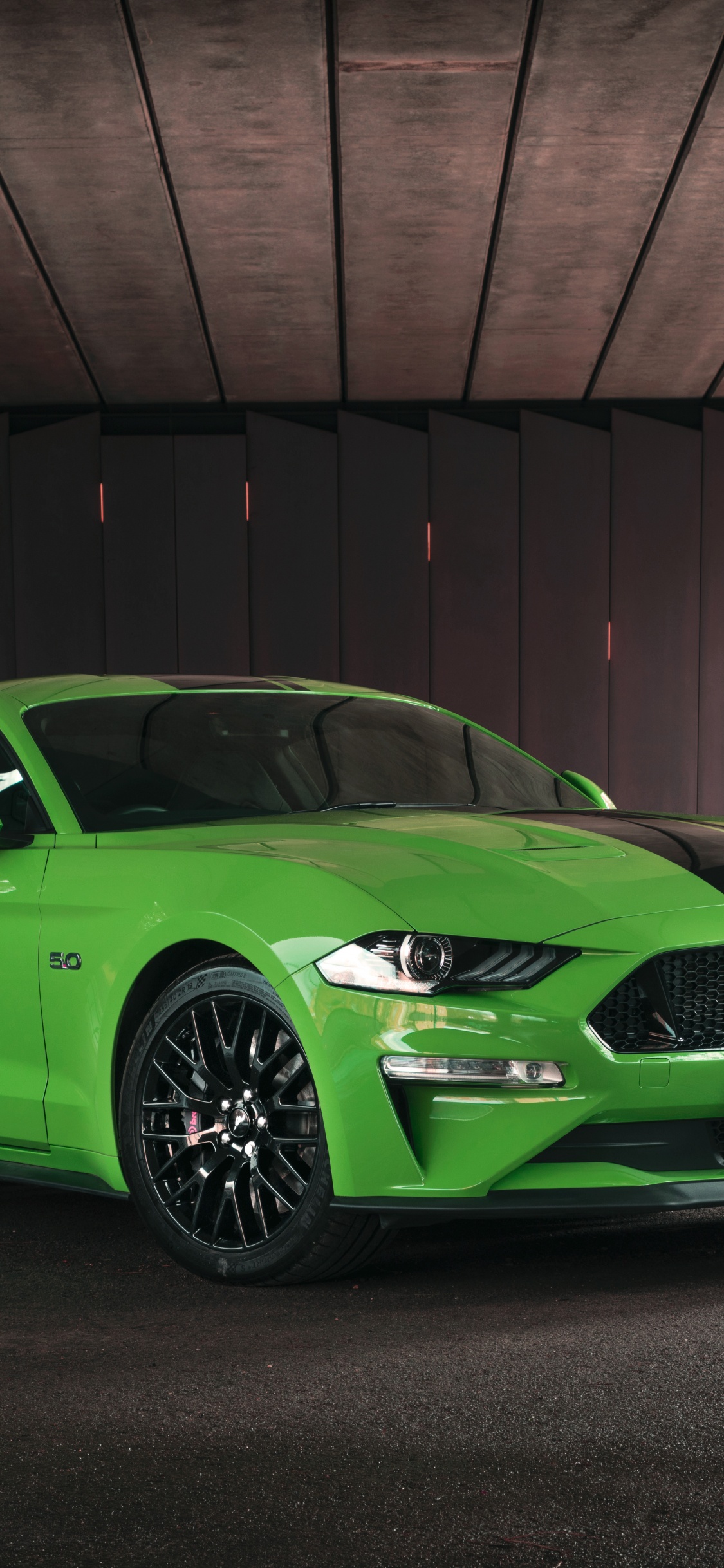 Grüner Porsche 911 Geparkt Neben Brauner Backsteinmauer. Wallpaper in 1125x2436 Resolution