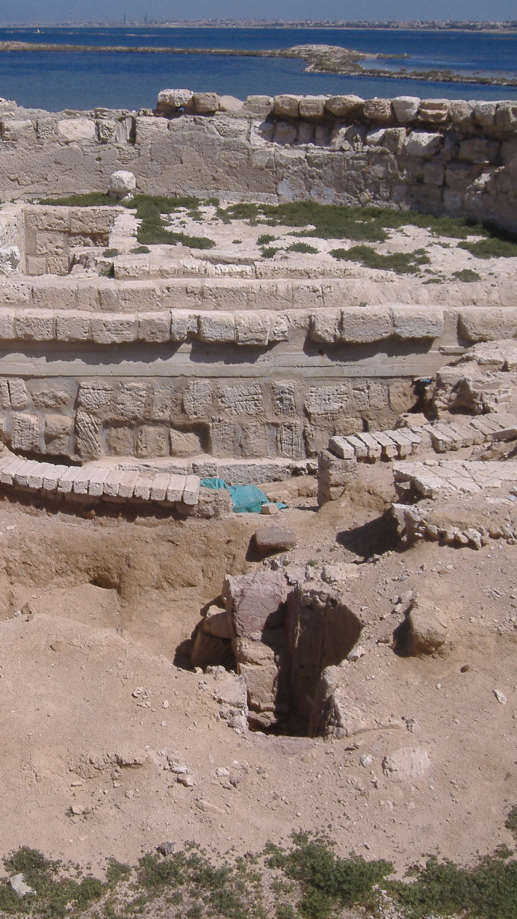 Personne en Chemise Bleue Assise Sur Une Formation Rocheuse Brune Pendant la Journée. Wallpaper in 750x1334 Resolution