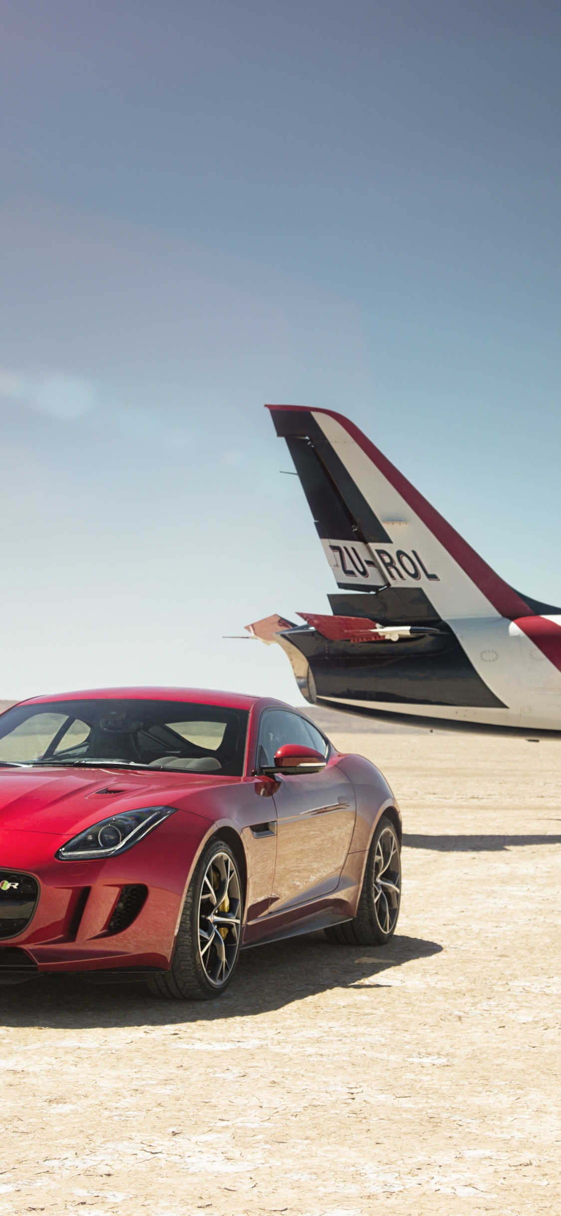 Rotes Und Weißes Flugzeug Auf Weißem Sand Tagsüber. Wallpaper in 1125x2436 Resolution