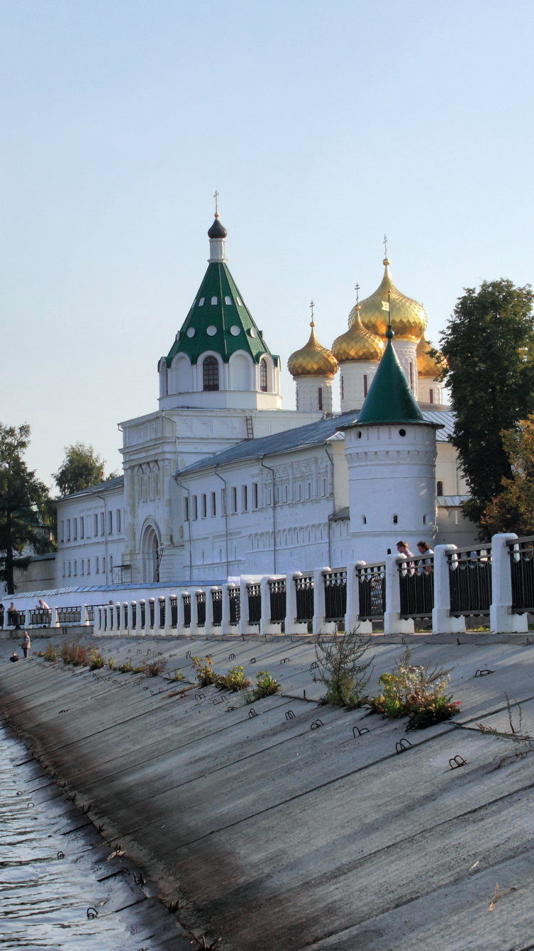 Edificio de Hormigón Blanco y Marrón Cerca Del Cuerpo de Agua Durante el Día. Wallpaper in 750x1334 Resolution