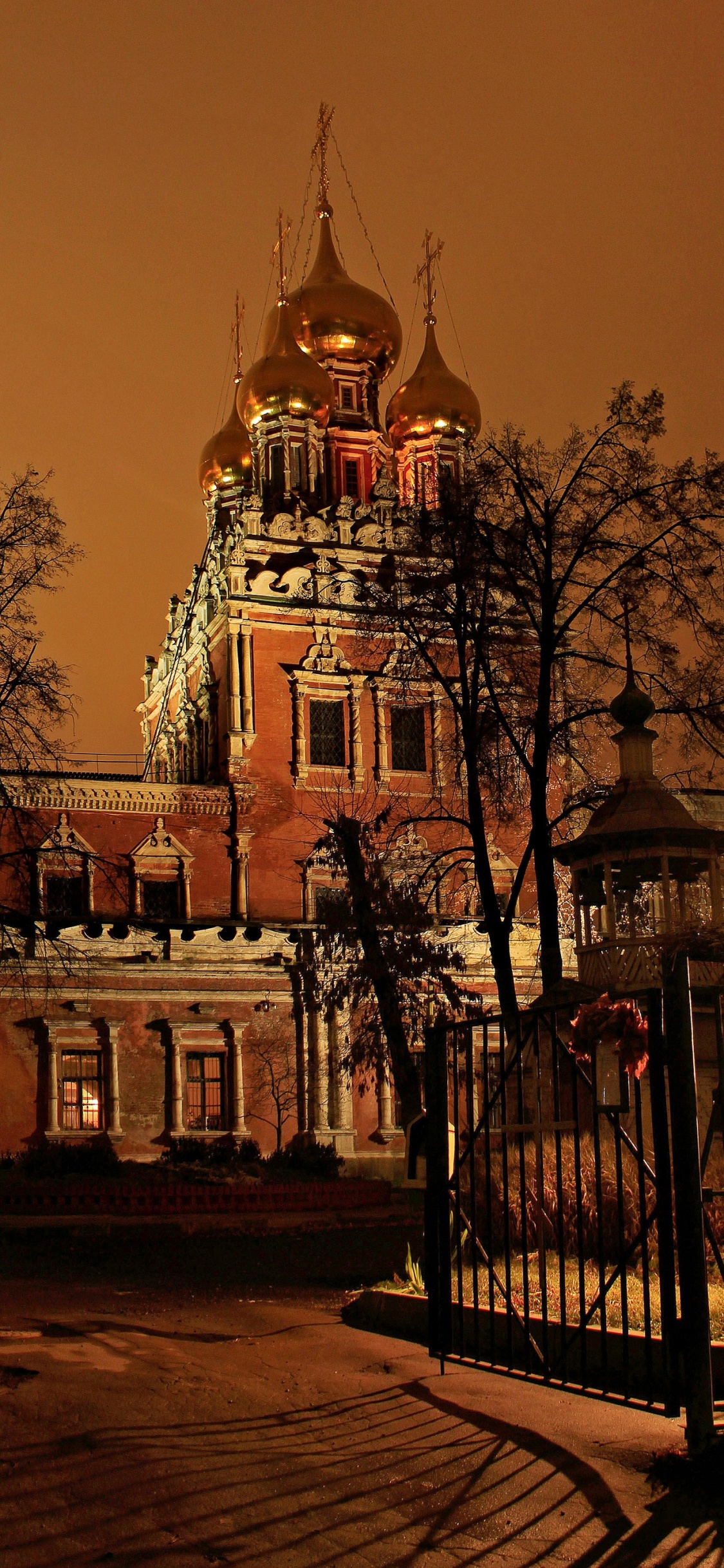 Weißes Und Grünes Betongebäude Während Der Nacht. Wallpaper in 1125x2436 Resolution