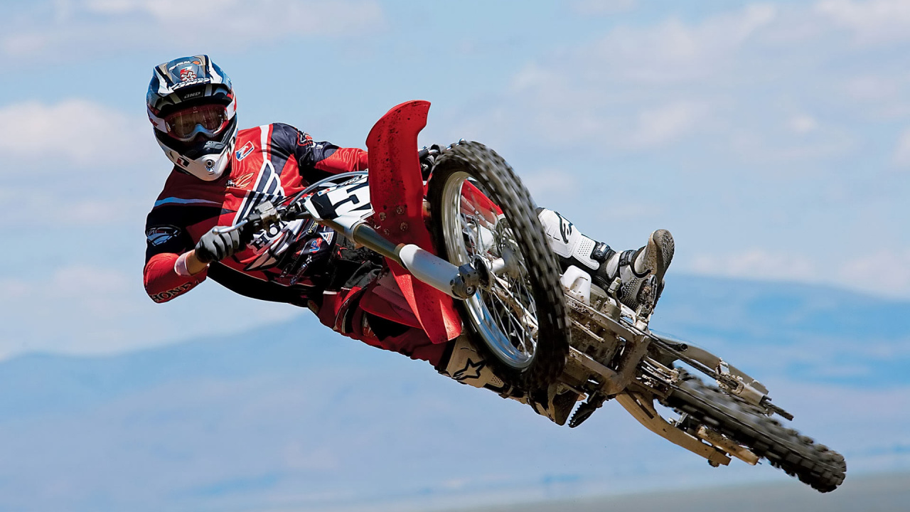 Man in Red and Black Motocross Suit Riding Motocross Dirt Bike. Wallpaper in 1280x720 Resolution