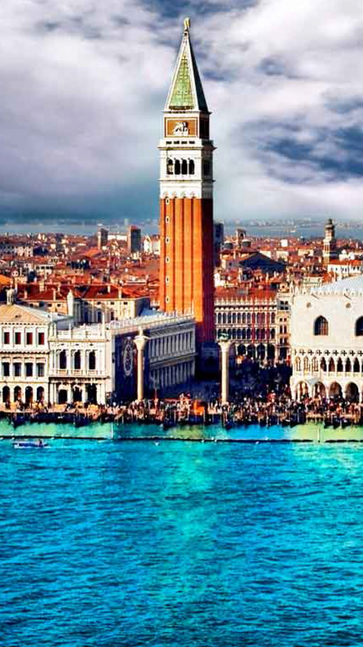 Bâtiment en Béton Blanc et Marron Près D'un Plan D'eau Sous un Ciel Nuageux Pendant la Journée. Wallpaper in 750x1334 Resolution