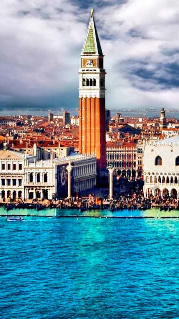 Weißes Und Braunes Betongebäude in Der Nähe Von Gewässern Unter Bewölktem Himmel Tagsüber. Wallpaper in 720x1280 Resolution