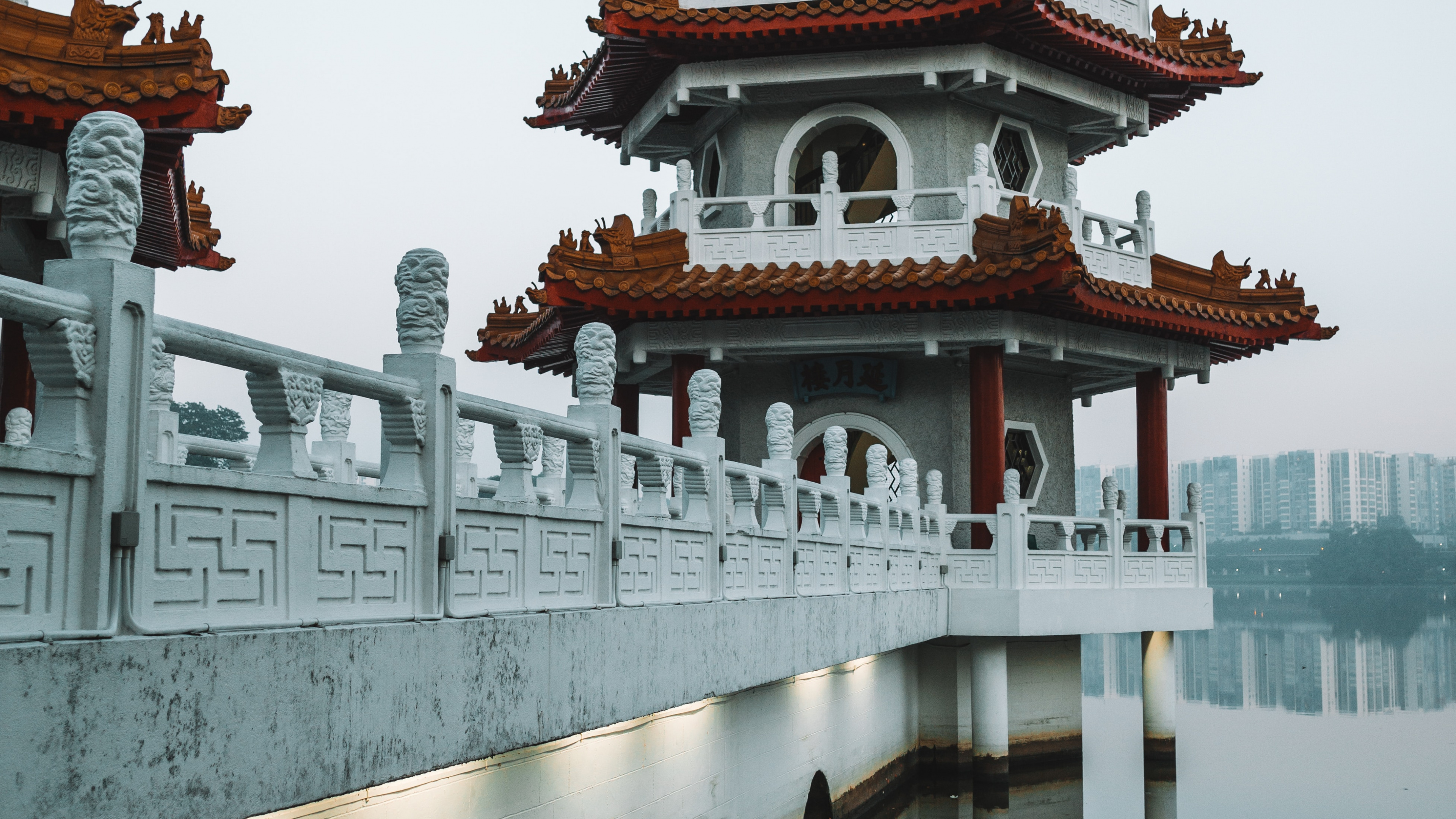 White and Red Concrete Building Near Body of Water During Daytime. Wallpaper in 3840x2160 Resolution