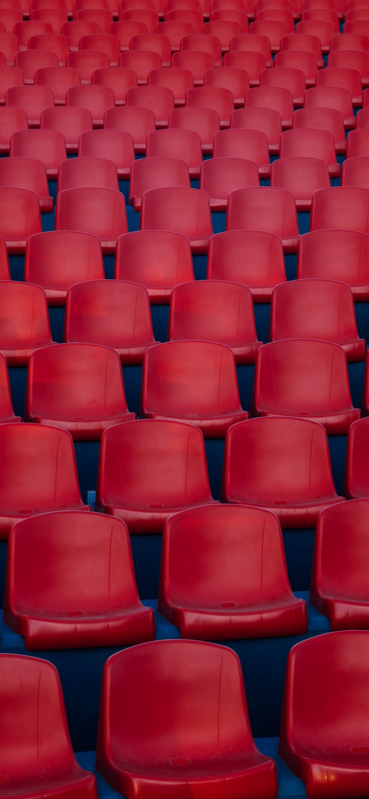 Red Plastic Chairs in Stadium. Wallpaper in 1242x2688 Resolution