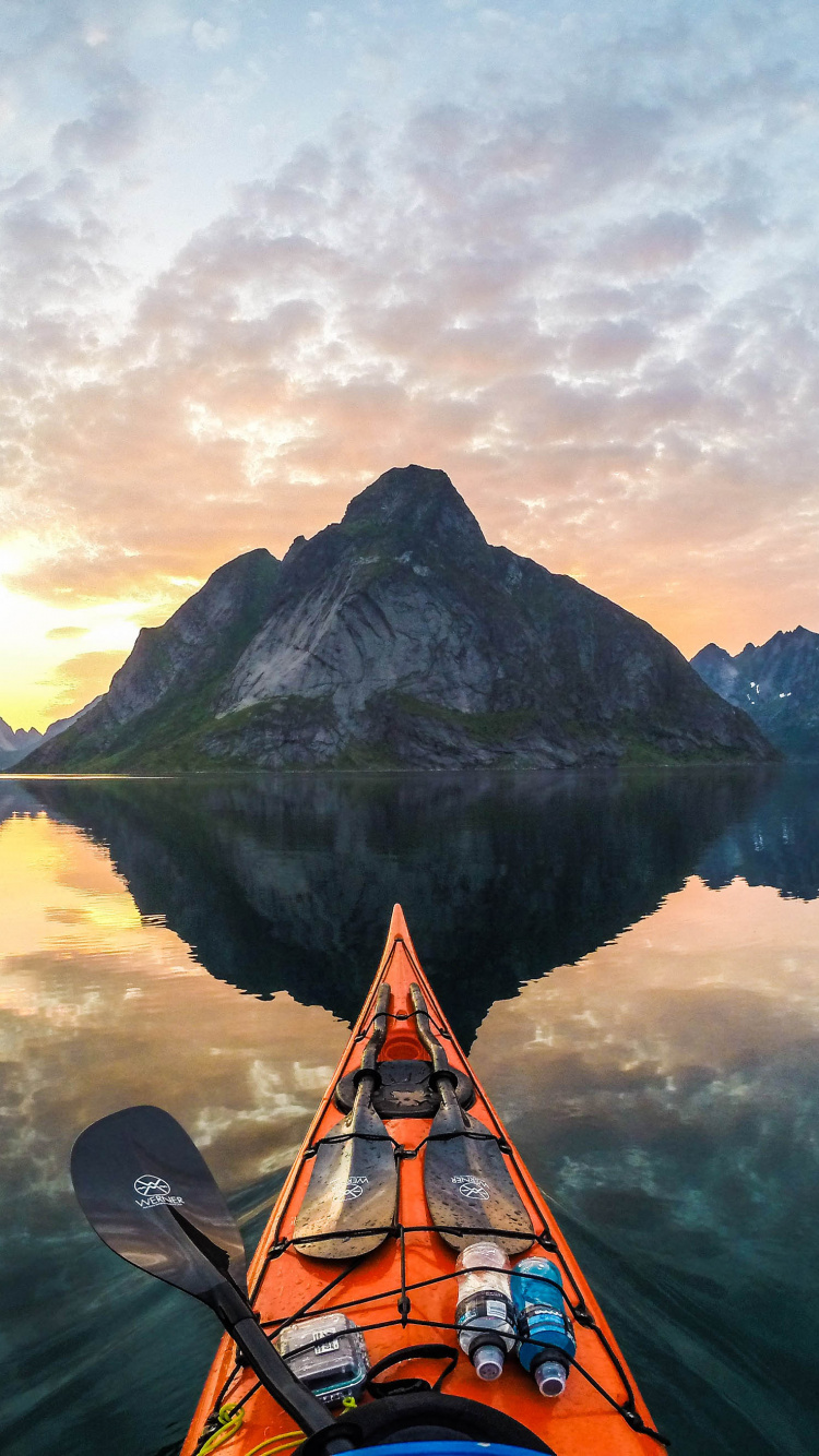Kayak Naranja en el Lago Cerca de la Montaña Bajo Nubes Blancas Durante el Día. Wallpaper in 750x1334 Resolution