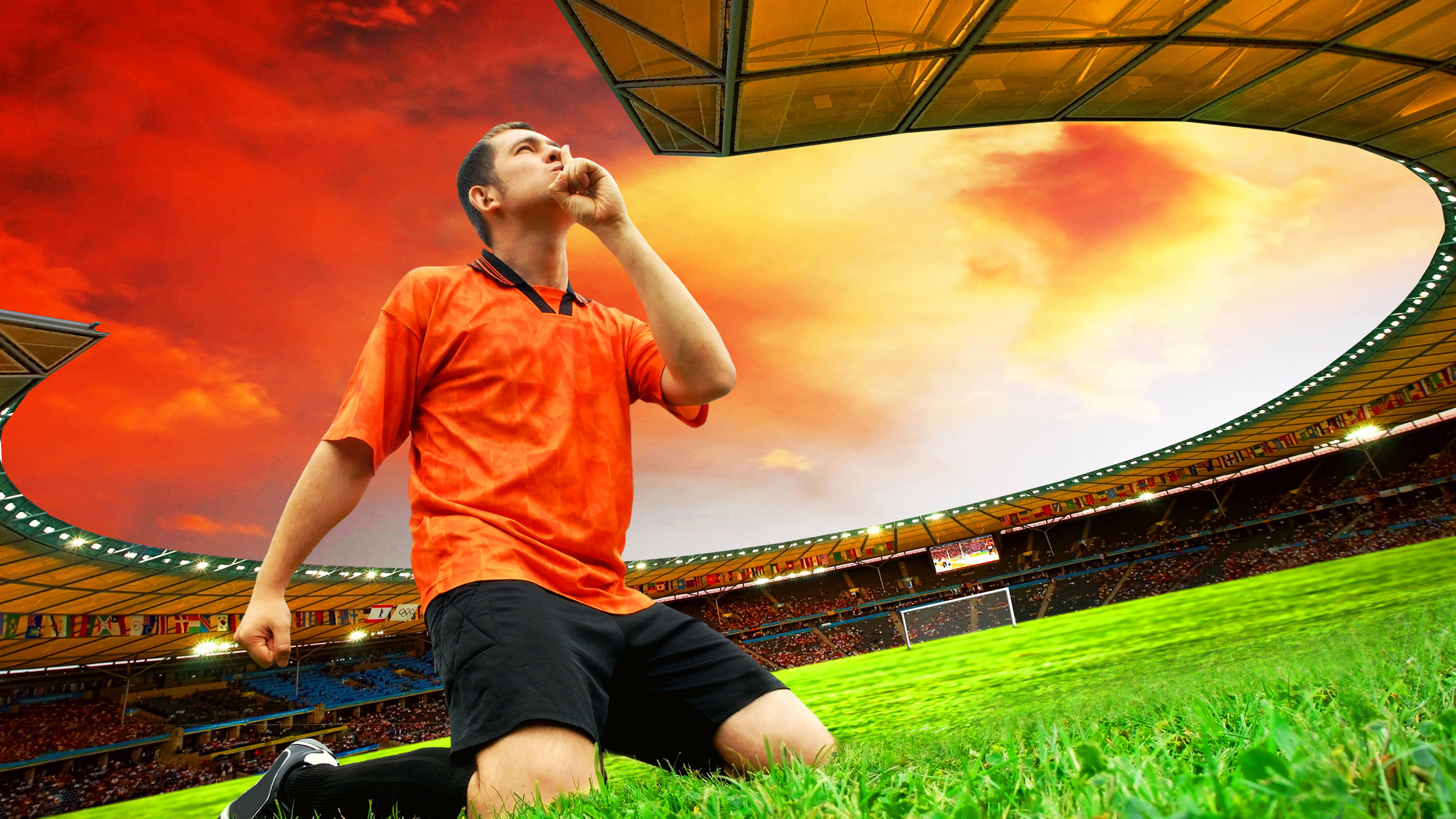 Mann im Roten T-Shirt Mit Rundhalsausschnitt Und Schwarzen Shorts Sitzt Auf Einer Grünen Wiese Grass. Wallpaper in 2560x1440 Resolution