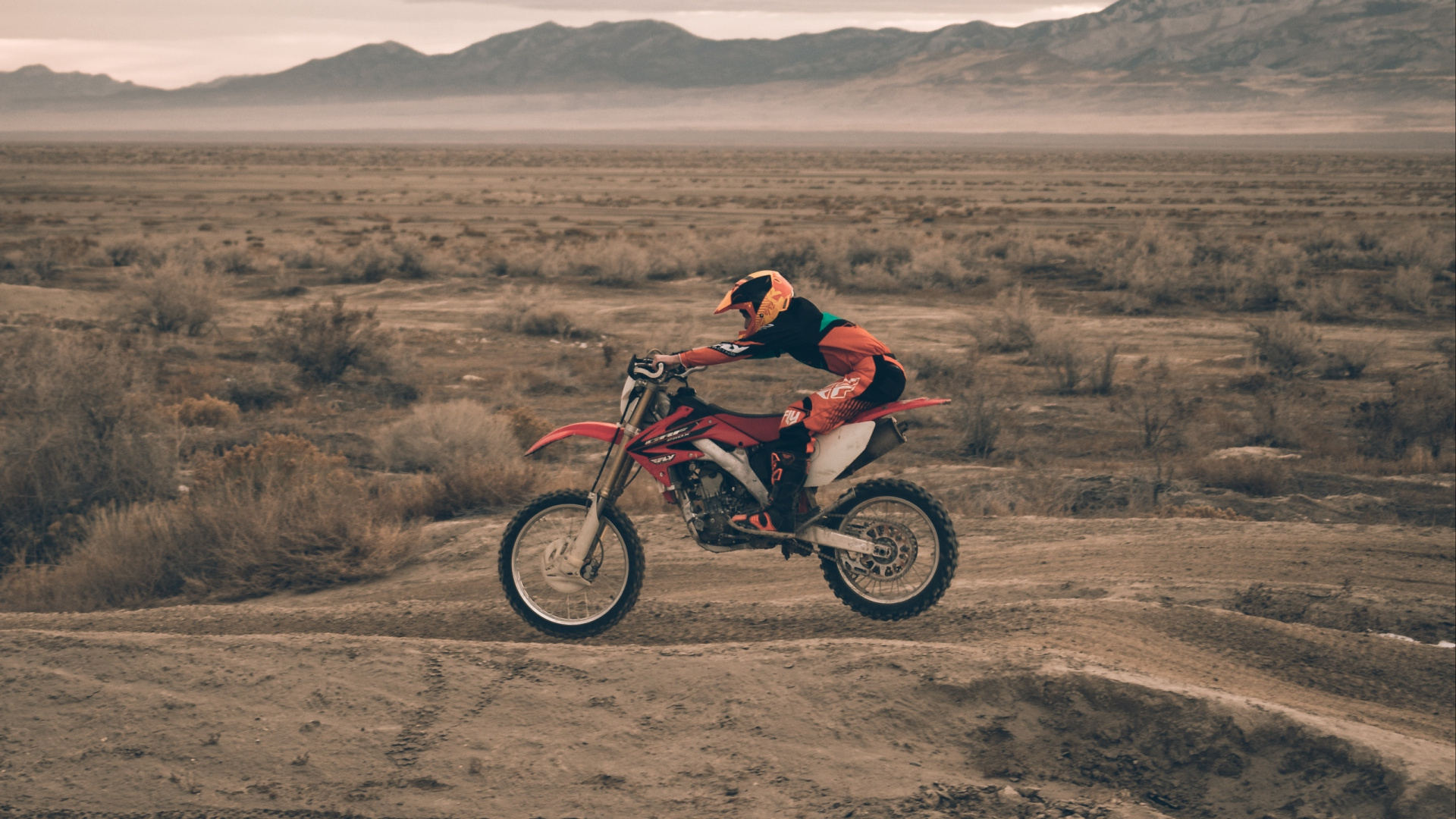 Man in Red Jacket Riding Motocross Dirt Bike on Brown Field During Daytime. Wallpaper in 1920x1080 Resolution