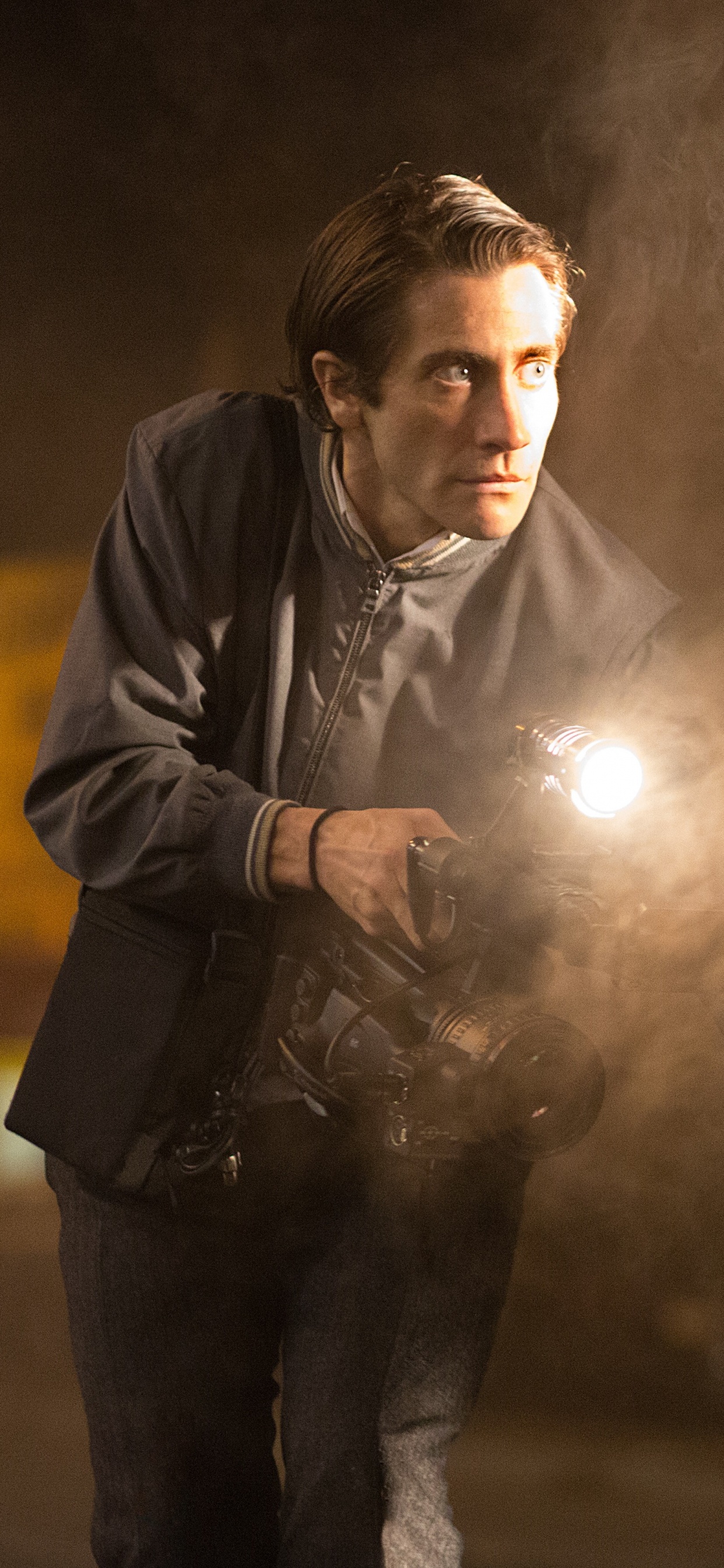 Man in Black Leather Jacket Holding a Light. Wallpaper in 1242x2688 Resolution