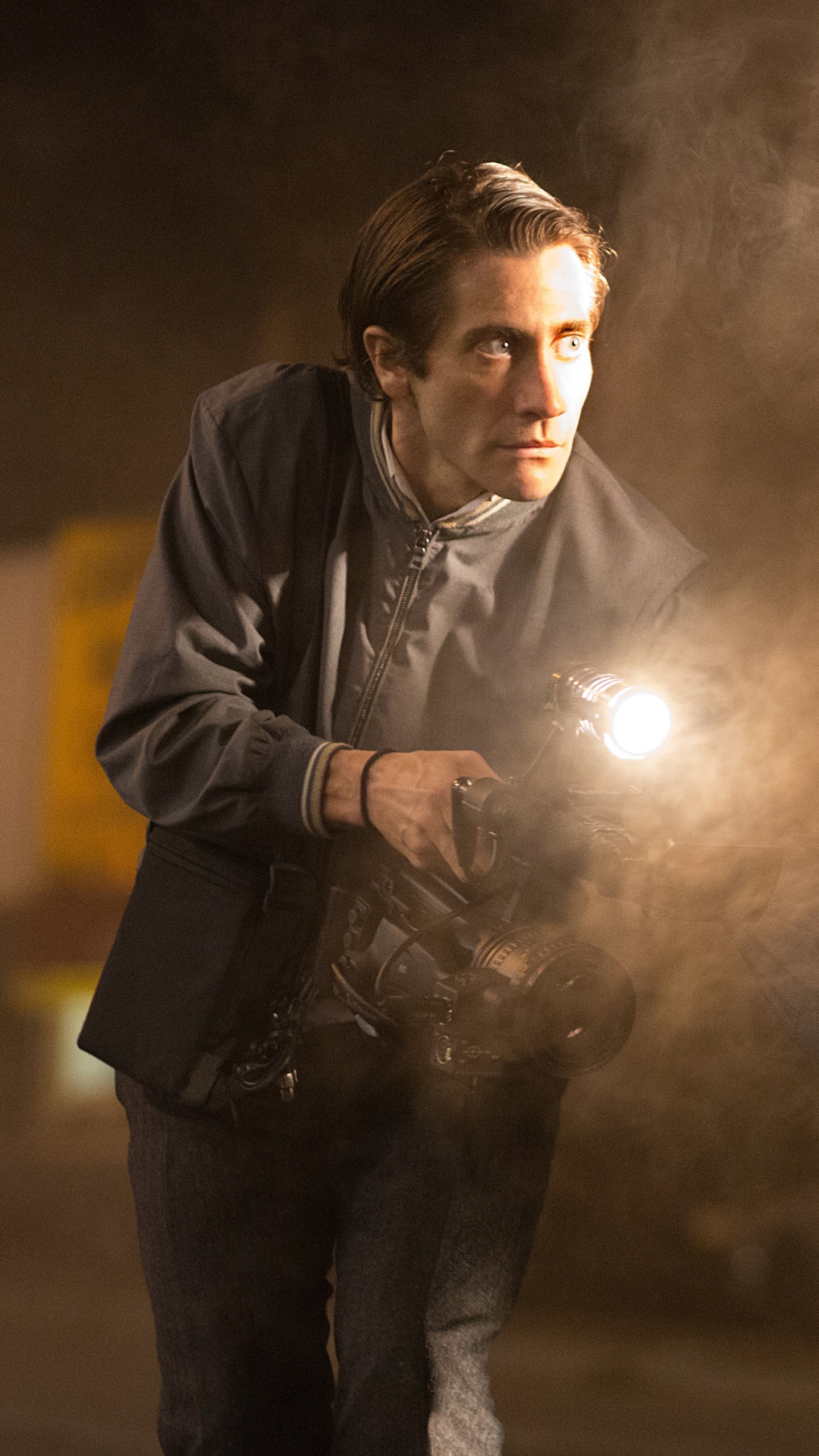 Man in Black Leather Jacket Holding a Light. Wallpaper in 1440x2560 Resolution