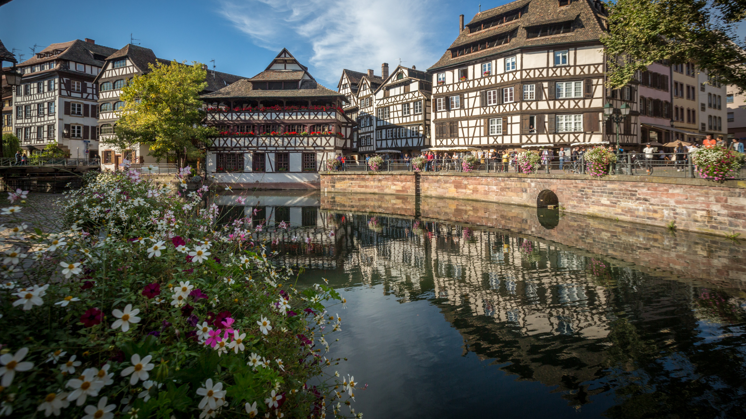 Braunes Betongebäude in Der Nähe Des Flusses Unter Blauem Himmel Tagsüber. Wallpaper in 2560x1440 Resolution