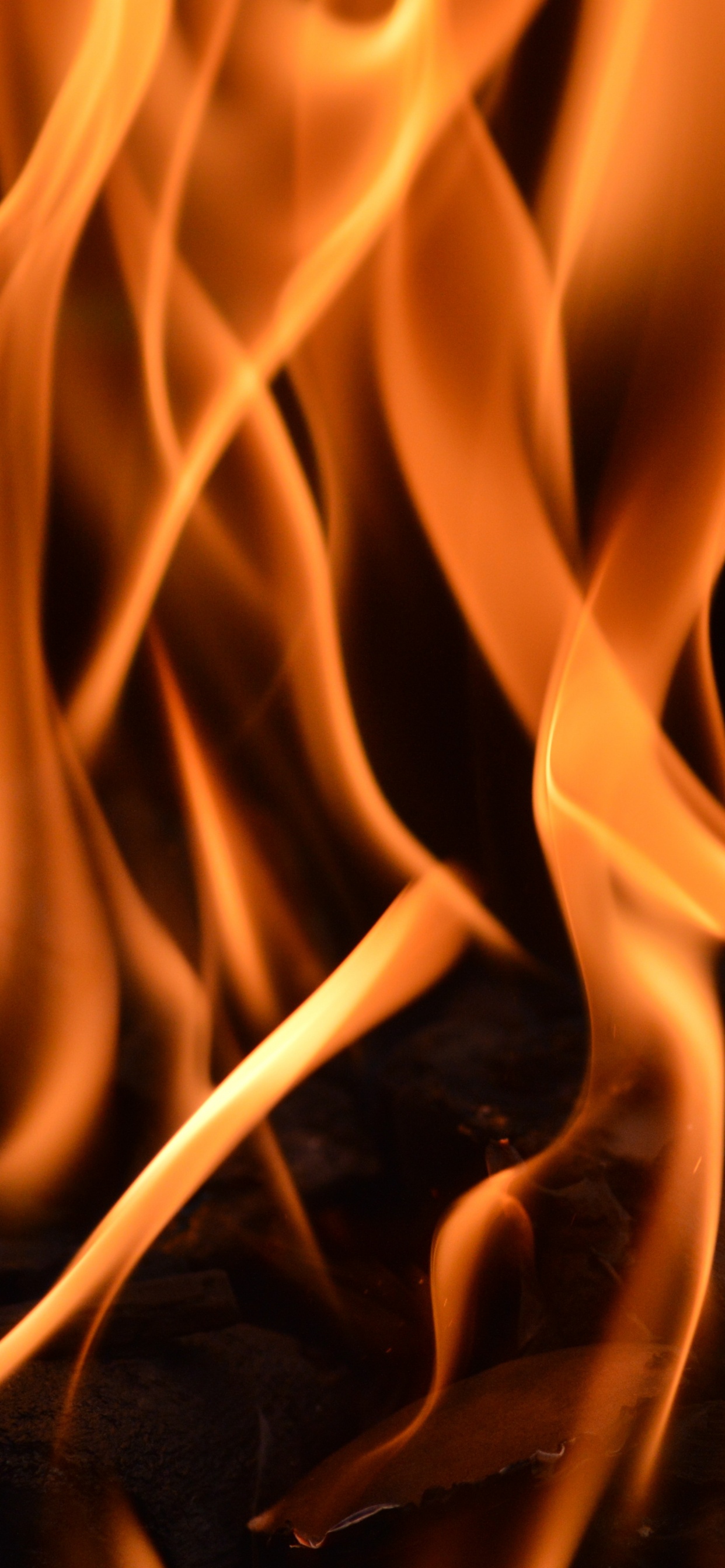 Orange Fire in Black Background. Wallpaper in 1242x2688 Resolution