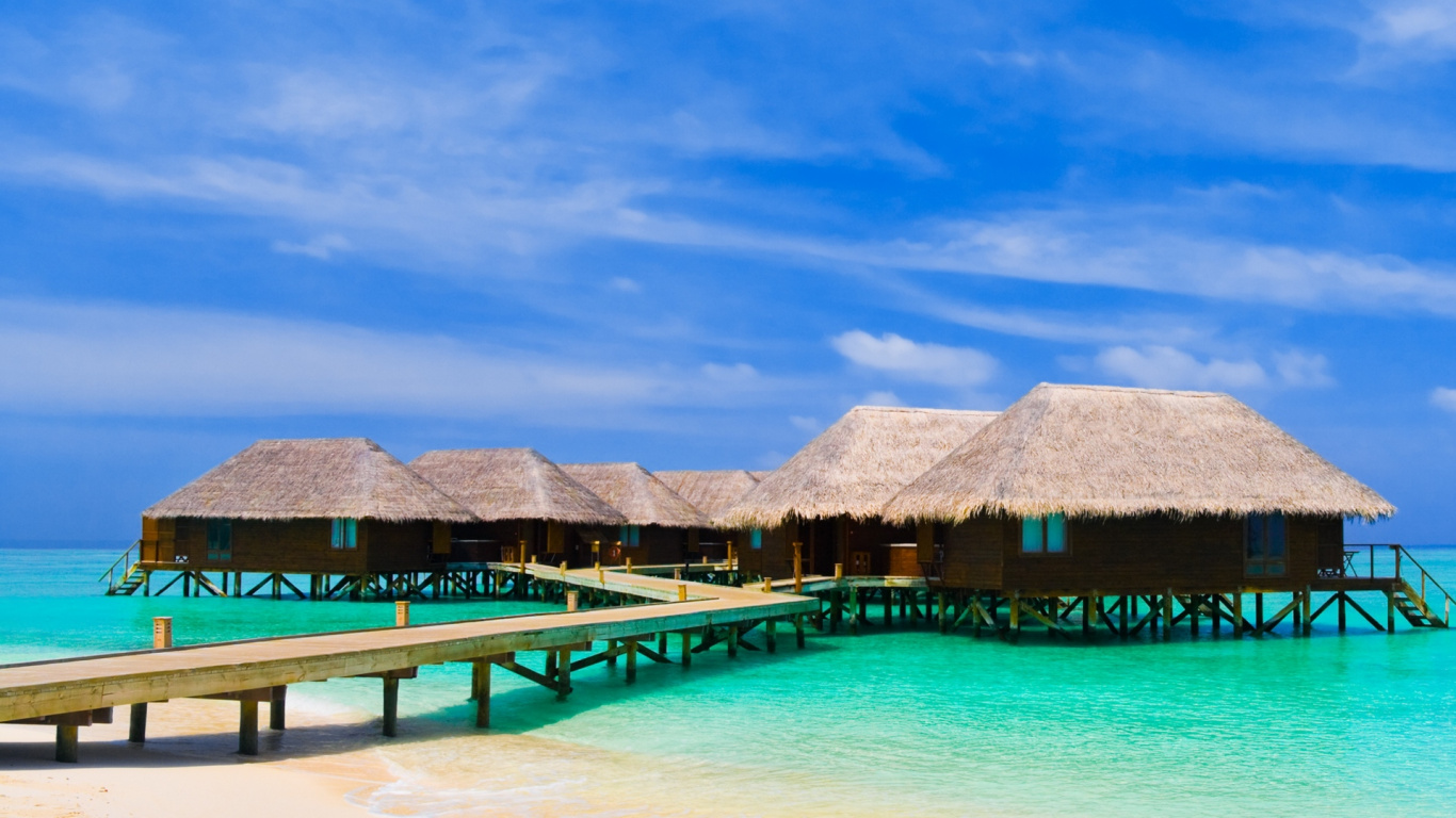 Brown Wooden Beach House on Blue Sea Under Blue Sky During Daytime. Wallpaper in 1366x768 Resolution