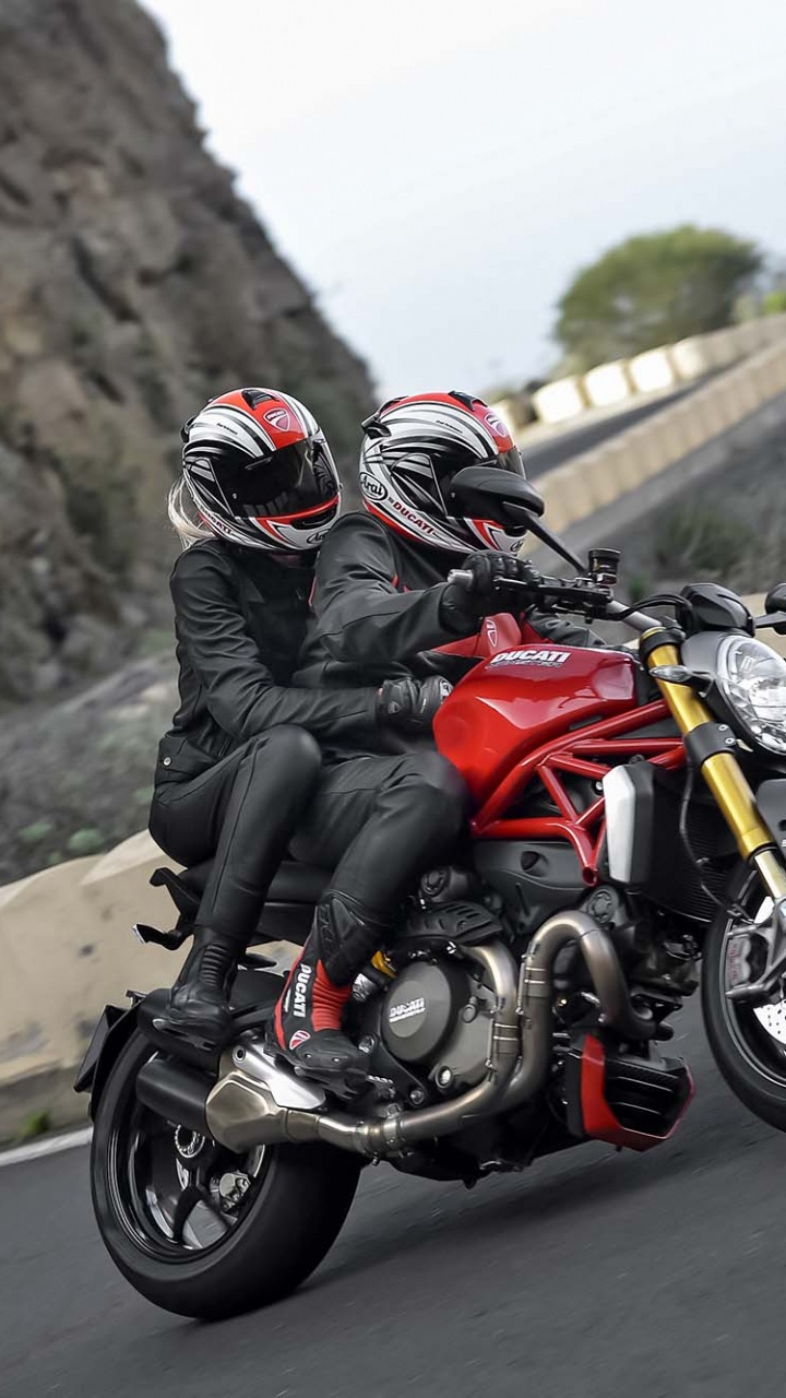 Man in Black and Red Motorcycle Suit Riding Motorcycle on Road During Daytime. Wallpaper in 720x1280 Resolution