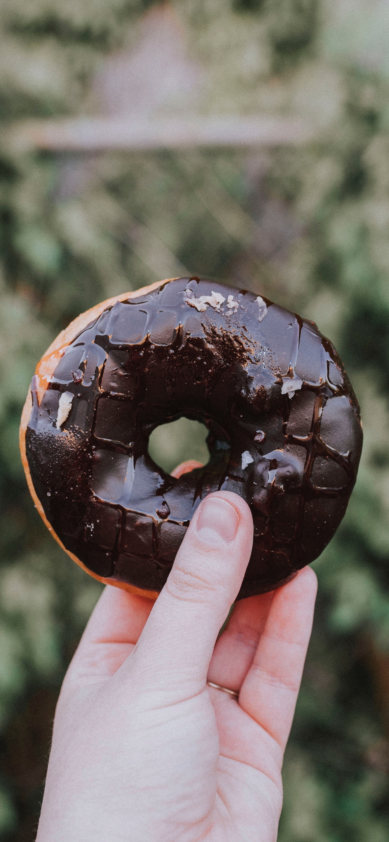 Person Holding Chocolate Coated Doughnut. Wallpaper in 1242x2688 Resolution