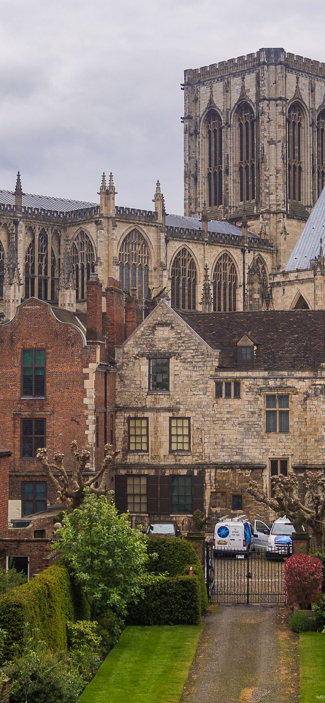 Bâtiment en Briques Brunes Près Des Arbres Verts Pendant la Journée. Wallpaper in 1125x2436 Resolution