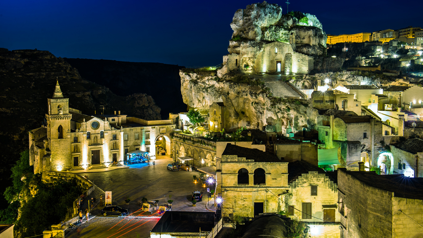 Brown Concrete Building Near Mountain During Night Time. Wallpaper in 1366x768 Resolution