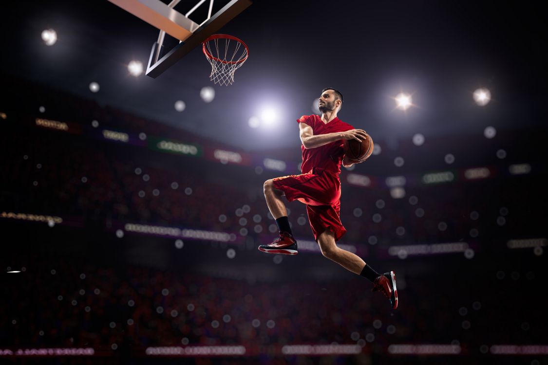 Mann in Rotem Trikot Und Shorts Springt Auf Basketballplatz. Wallpaper in 8000x5333 Resolution