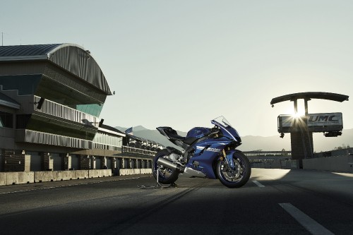 Image blue and black sports bike parked on gray concrete road during daytime