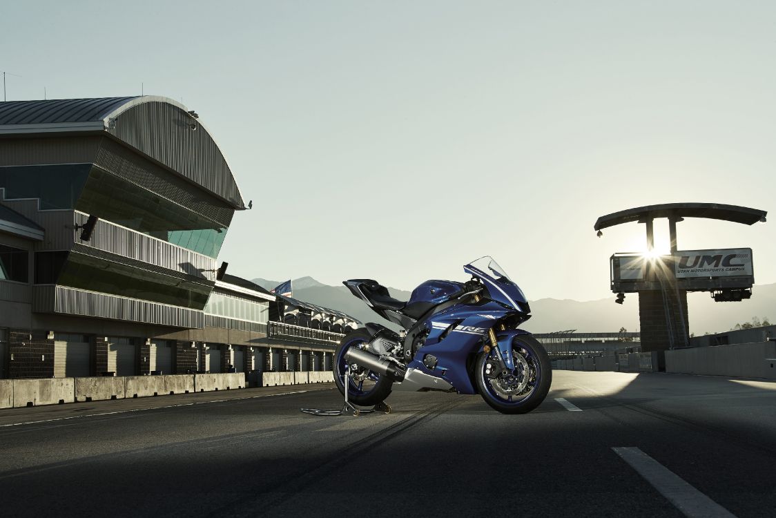 blue and black sports bike parked on gray concrete road during daytime