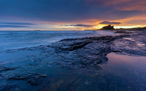 Image ocean waves crashing on shore during sunset