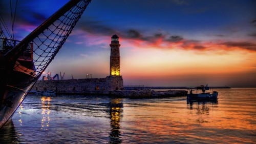 Image brown and black tower near body of water during sunset